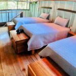 A room with three beds and wooden floors