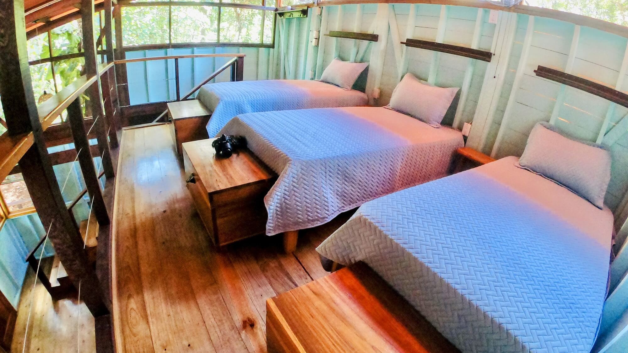A room with three beds and wooden floors