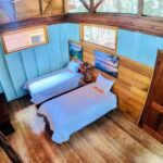 A room with two beds and wooden walls