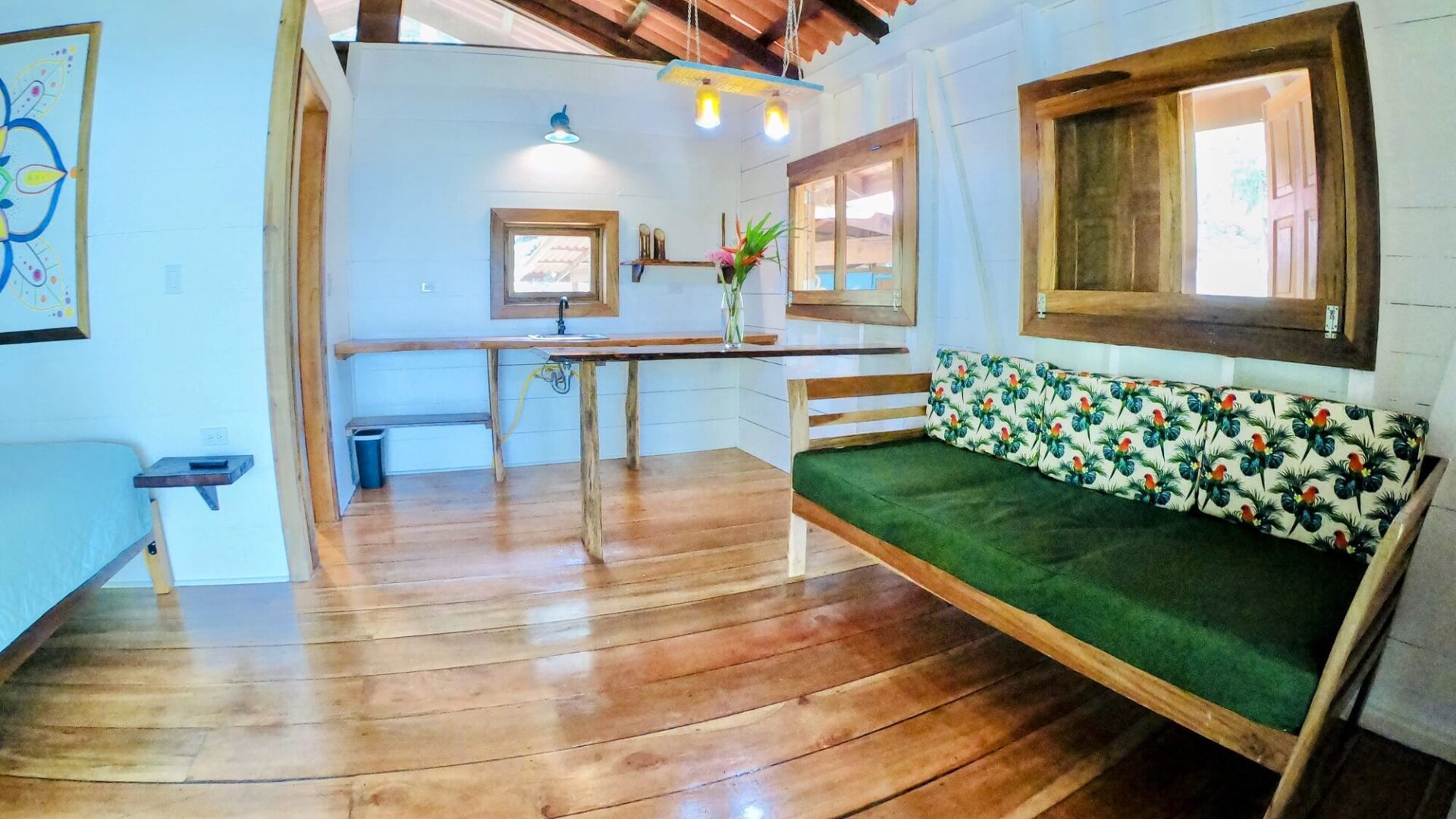 A room with wooden floors and green furniture.