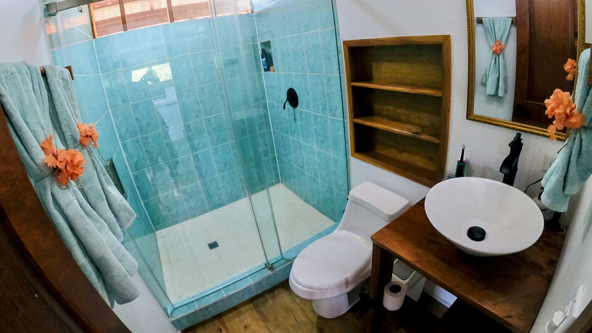 A bathroom with a toilet, sink and shower.