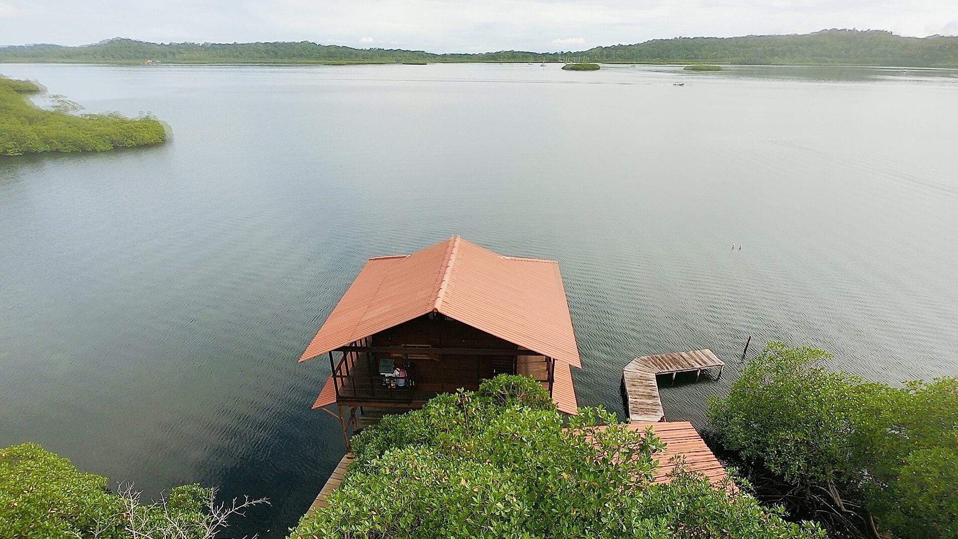 A boat house is sitting on the water.