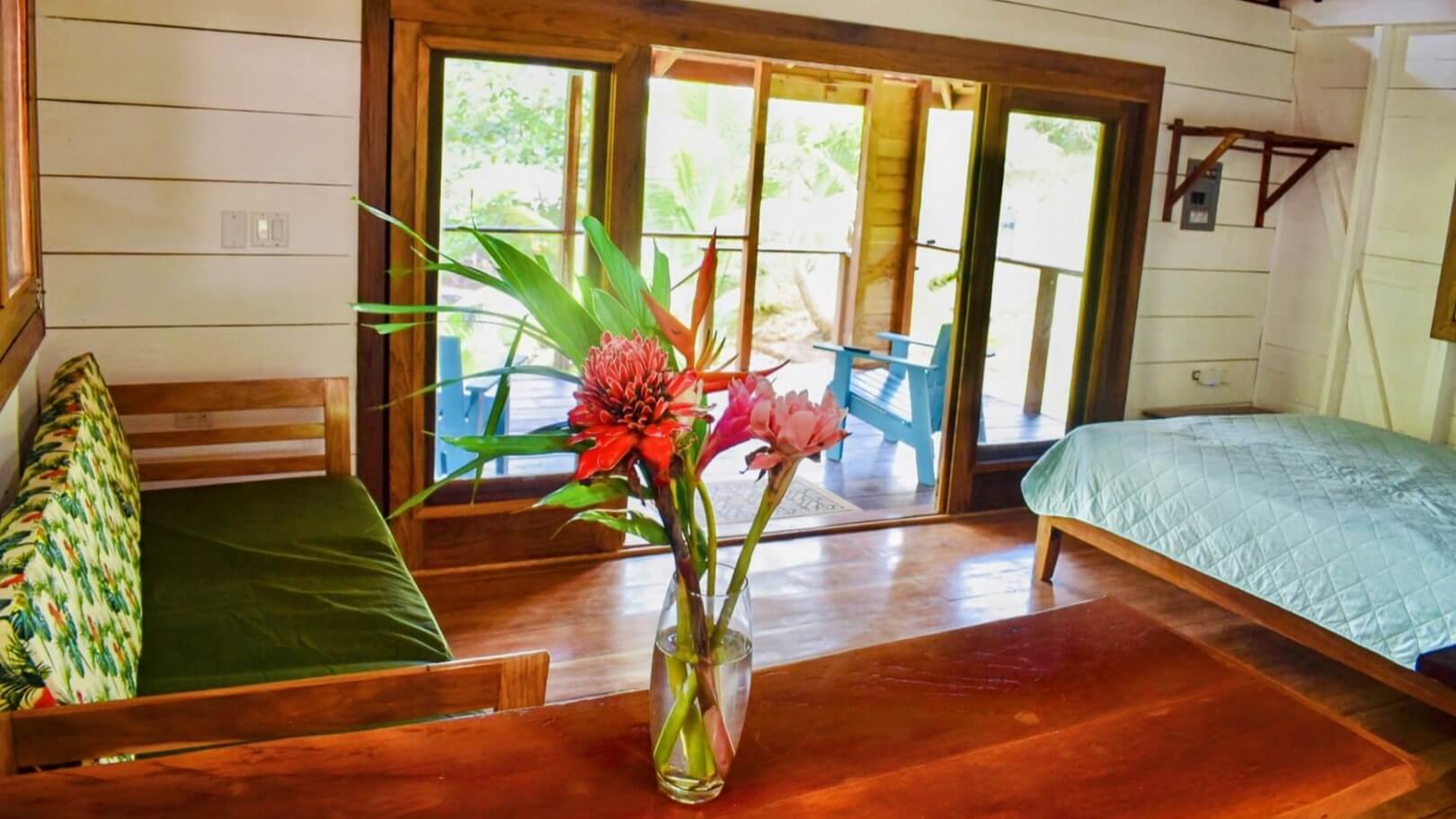 A vase of flowers on the table in front of a window.