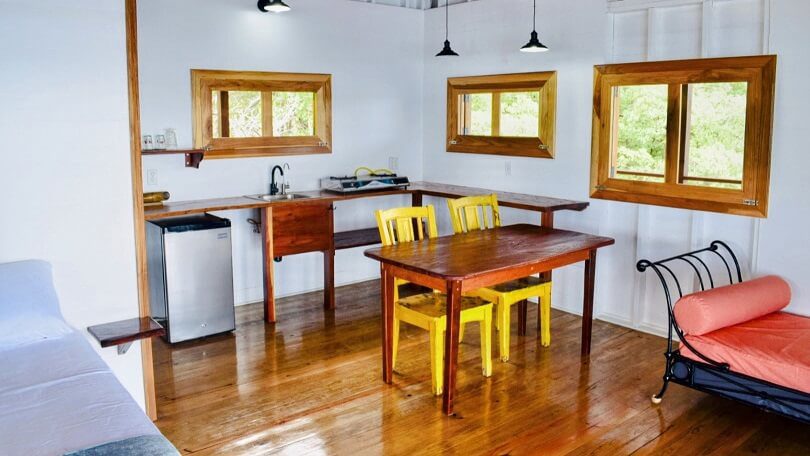 A kitchen with wooden floors and yellow chairs.