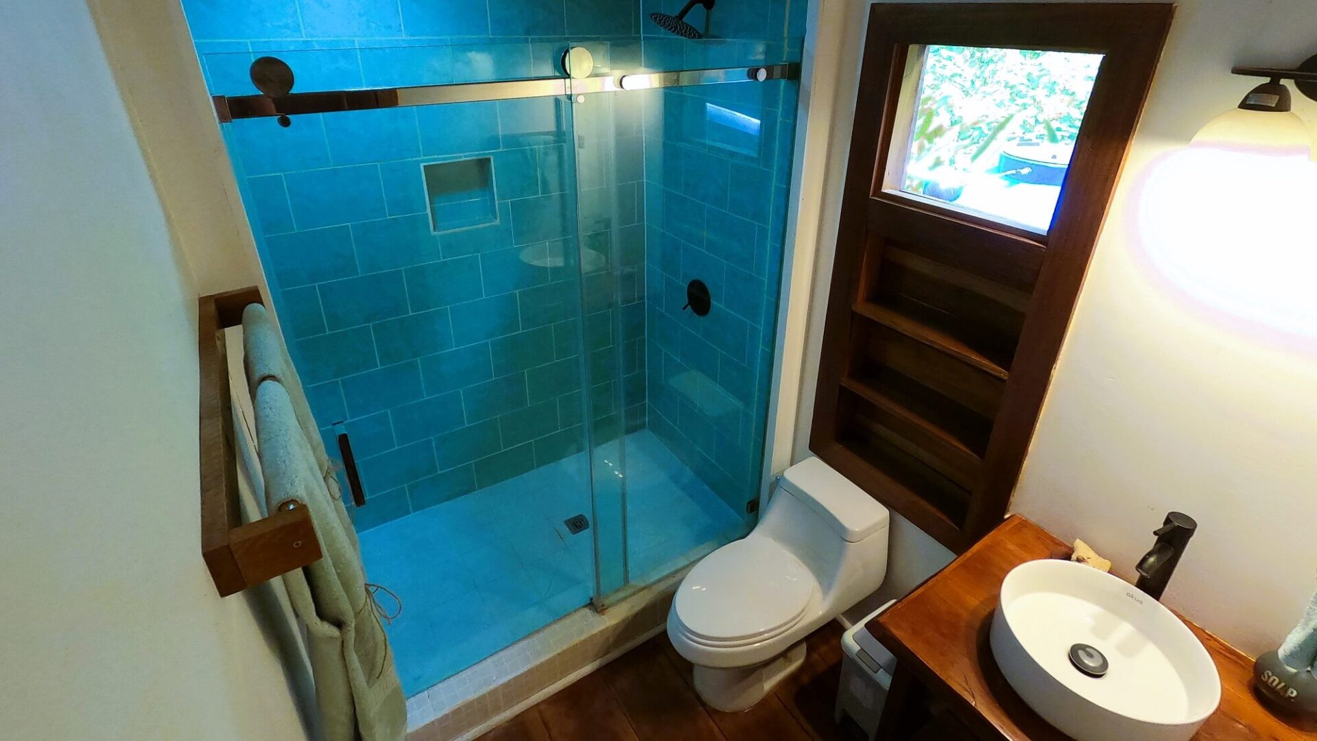 A bathroom with a toilet, shower and sink.