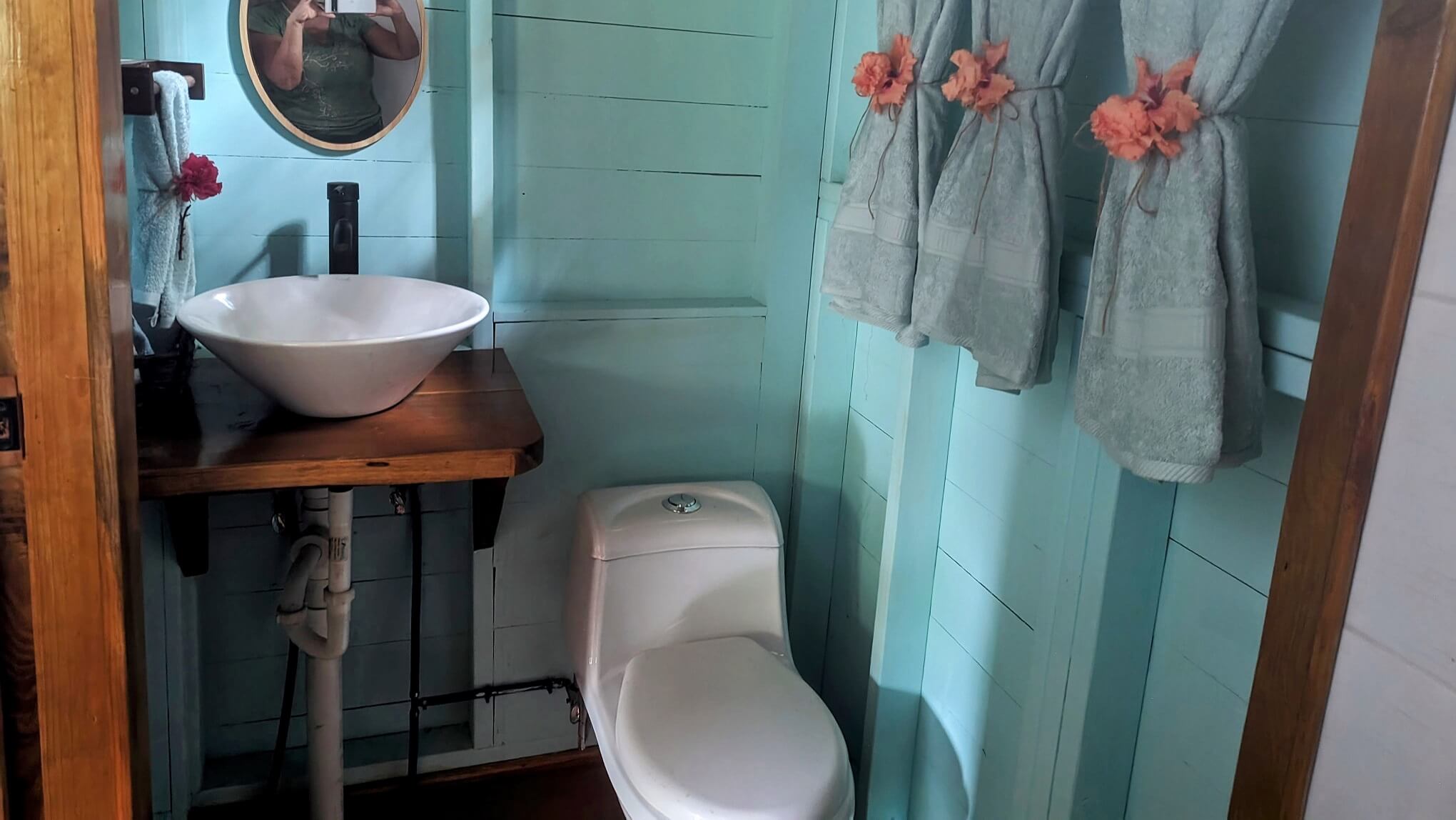 A bathroom with blue walls and white toilet.