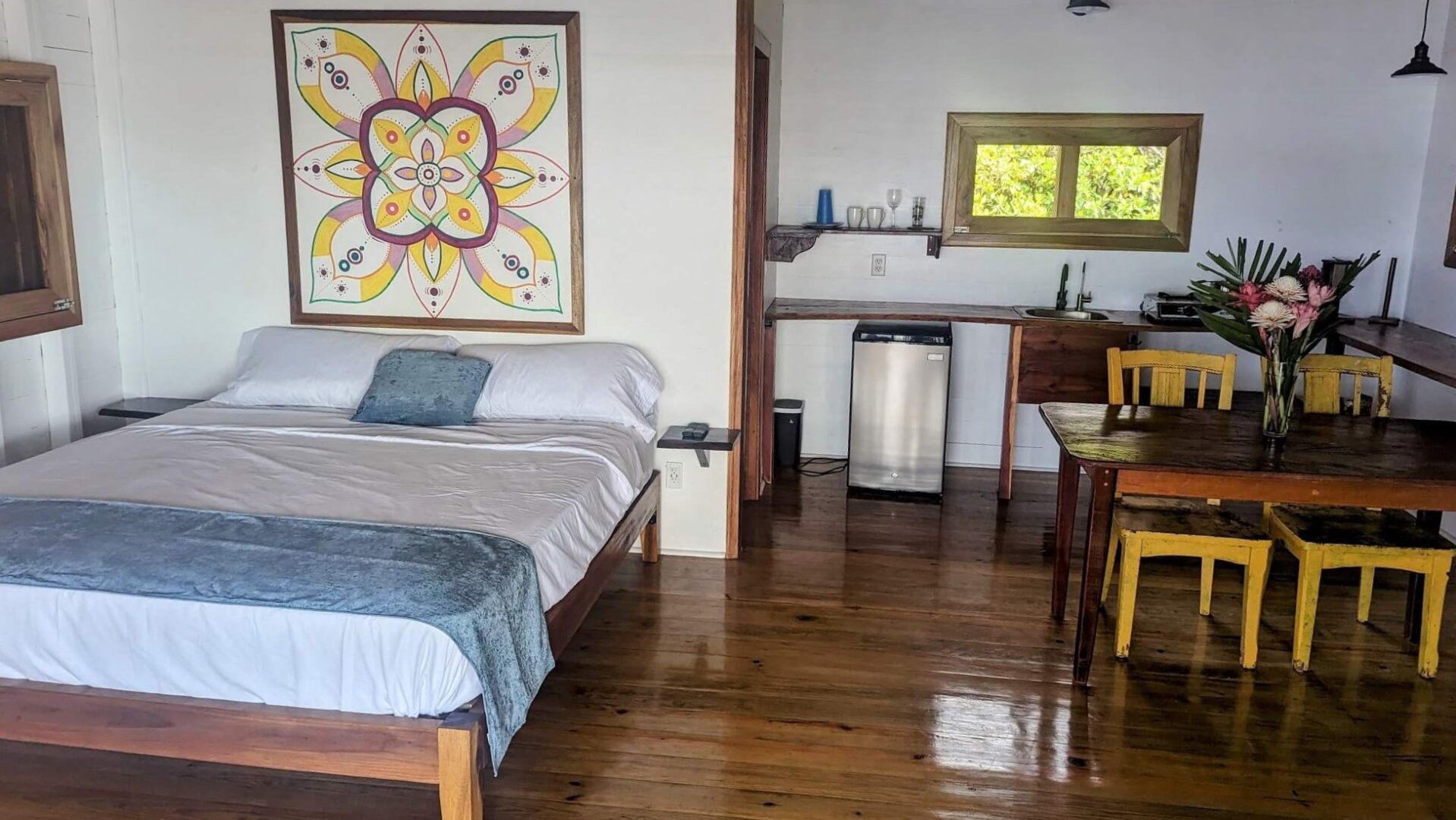 A bedroom with wood floors and a bed.