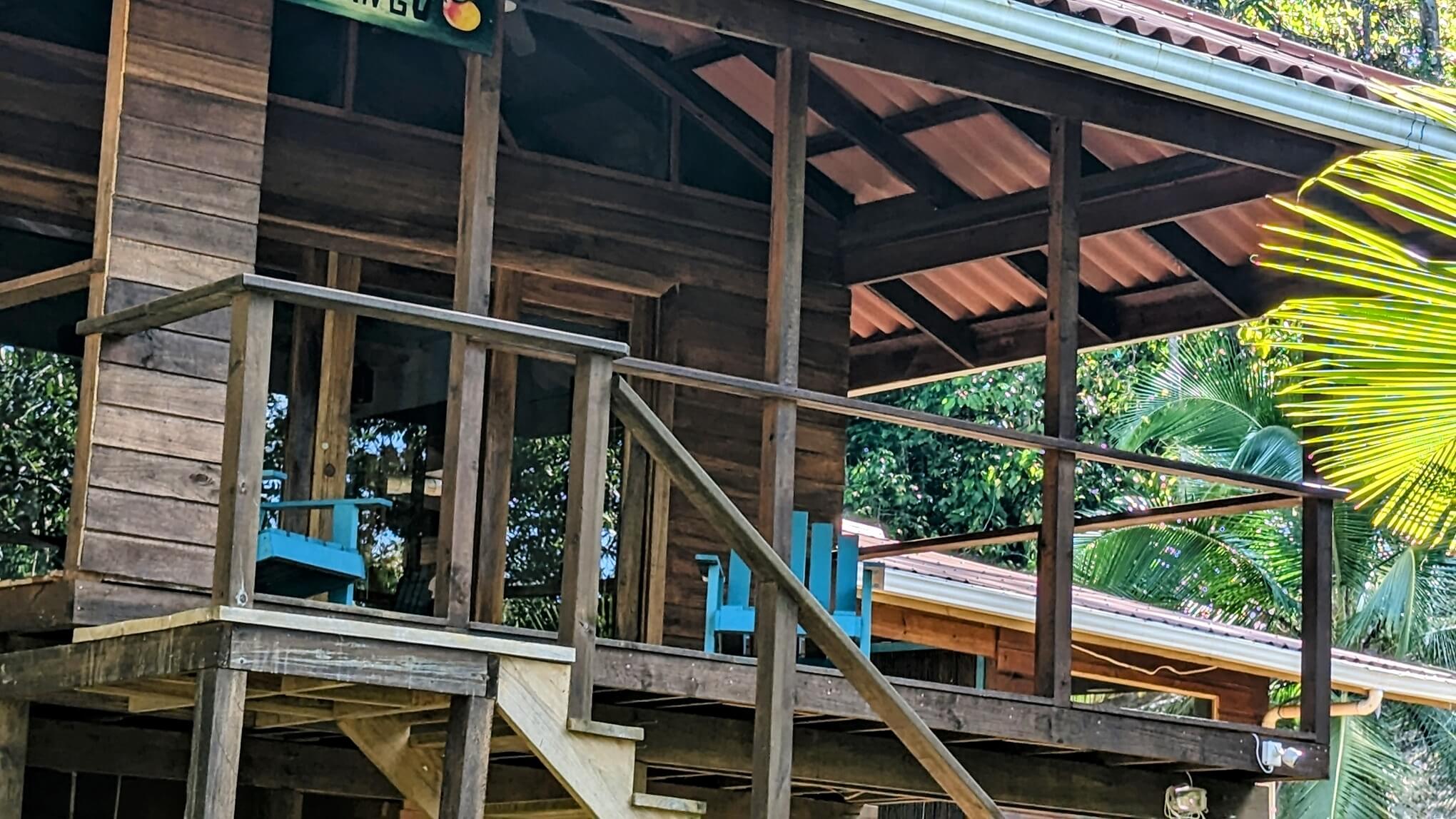 A wooden deck with stairs leading to the porch.