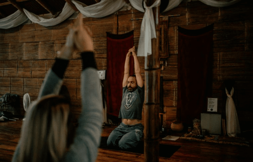 A man is doing yoga in the middle of a room.