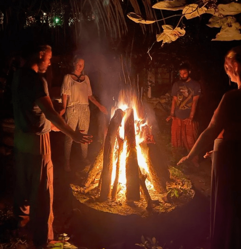 A group of people around a fire in the dark.