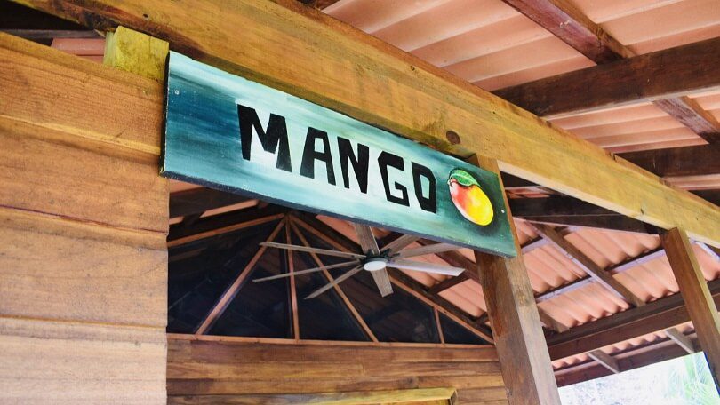 A sign that says mango hanging from the ceiling.